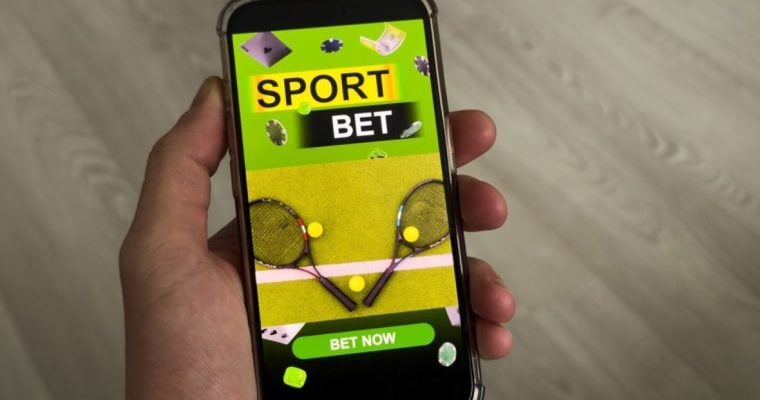 Tennis Raqettes and Balls Below Text Sport Bet on Cell Phone Held in Hand
