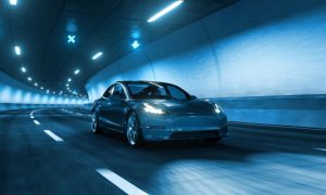 Sleek Modern Car Speeds Through Tunnel With White Lights Overhead