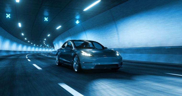 Sleek Modern Car Speeds Through Tunnel With White Lights Overhead