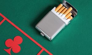 Green Casino Games Table with Red Clubs Symbol and Cigarettes Inside Silver Case