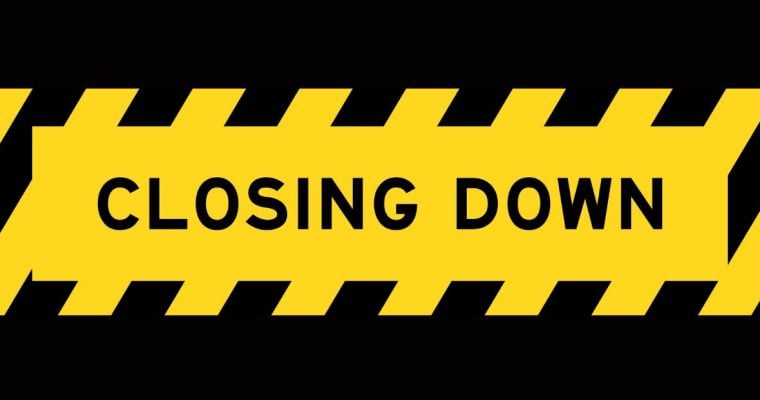 Caution Tape Reads Closing Down on Black Background