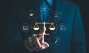 Golden Scales Of Justice Overlay Image Of Man In A Suit Pointing to It