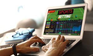 Man Uses Laptop To Access Sports Betting While Sitting At Desk