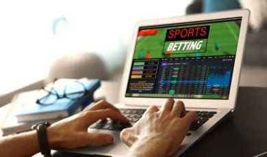 Man Uses Laptop To Access Sports Betting While Sitting At Desk