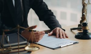 Man in Suit Sits At Desk Reviewing Legal Document