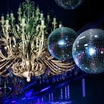 Camera Flash Lights Up Disco Balls and Huge Chandelier Hanging Inside Night Club