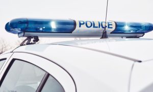 White Police Car Features Blue Lights on Top With Word Police In Center