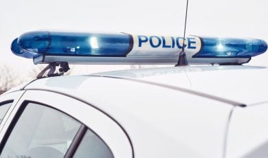 White Police Car Features Blue Lights on Top With Word Police In Center