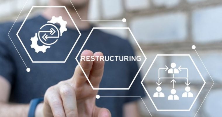 Man Points with Two Fingers to the Word Restructuring in Digital Icon Overlay