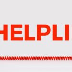 Red Telephone with Wire Corde Sits Below the Word Helpline in Red Letters
