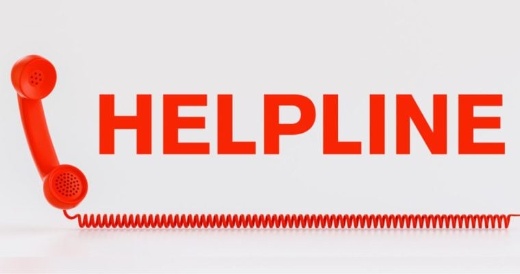 Red Telephone with Wire Corde Sits Below the Word Helpline in Red Letters