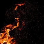 Burning Embers Fly Around Fire Flame on Black Background
