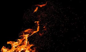 Burning Embers Fly Around Fire Flame on Black Background