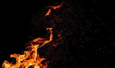 Burning Embers Fly Around Fire Flame on Black Background