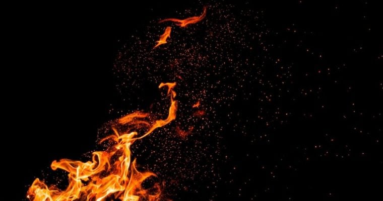 Burning Embers Fly Around Fire Flame on Black Background