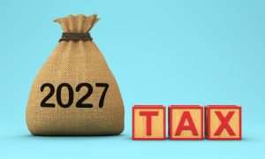 Brown Pouch Says 2027 Sitting Next To Wooden Blocks Spelling the Word TAX in Red
