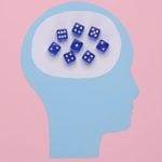 Art Collage of Head Made with Blue Paper and Blue Dice Inside on Pink Background