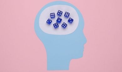 Art Collage of Head Made with Blue Paper and Blue Dice Inside on Pink Background