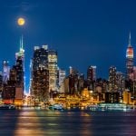 Night Time View of NYC Buildings on the Waterfront with Moon Hanging Above