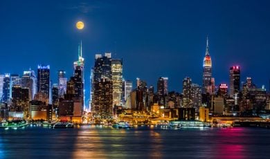 Night Time View of NYC Buildings on the Waterfront with Moon Hanging Above
