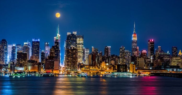 Night Time View of NYC Buildings on the Waterfront with Moon Hanging Above
