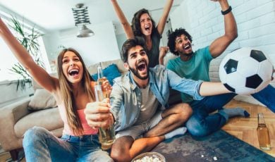 Group of Young People Celebrates While Watching Soccer Match At Home
