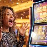 Young African American Woman Excited Next to Slot Machine with Jackpot Win