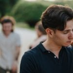 Man with Anxiety and Social Problem Excludes Himself From Friend Group in Background