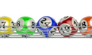 Yellow, Green, Blue, Red and Orange Numbered Lottery Balls Sit on Silver Metal Rack