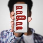 Negative Messages Displayed on Man's Cell Phone Covering His Face