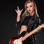 Young Woman in Studded Black Leather Jacket Holds Electric Guitar