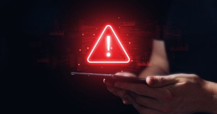 Red Digital Warning Sign Displayed over Tablet Held By Man in Black T-Shirt