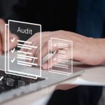 Man Uses Laptop with Digital Image Overlay of Papers with Audit Checks