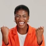 Happy Black Woman Smiling with Eyes Closed in Orange Jacket