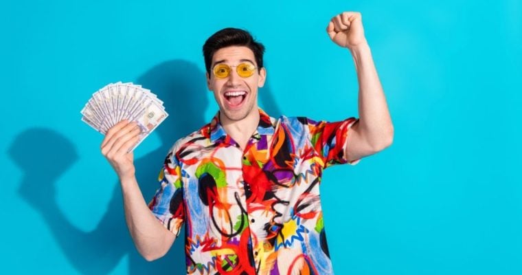 Man with Yellow Glasses and Colorful Shirt Hold Fanned Cash with Happy Expression
