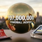 Gold Power Ball Reads $700,000,000 with Tablet Beside it Displaying Next Drawing is Saturday