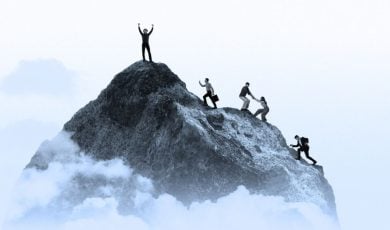 A Group of People Climb Grey Mountain Toward Peak on White Background