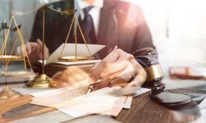 Several Images Exposed Over Each Other: Man in Black Suit, Judges Gavel, Gold Scales and Legal Papers