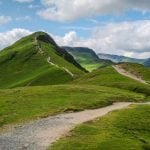 Grassy Mountain With Clear Path and Cloudy Skies