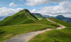 Grassy Mountain With Clear Path and Cloudy Skies