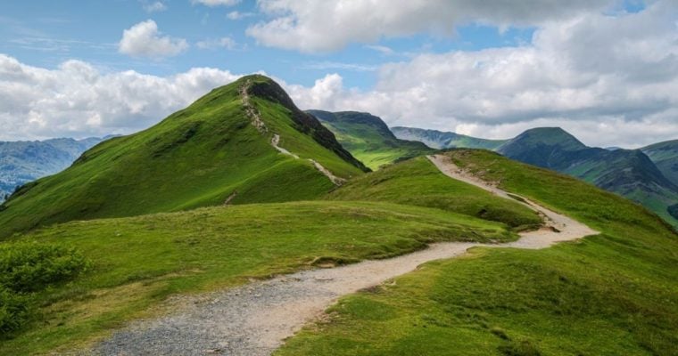 Grassy Mountain With Clear Path and Cloudy Skies