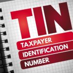 Open Notebook on Grey Background Reads TIN Taxpayer Identification Number