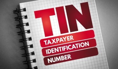 Open Notebook on Grey Background Reads TIN Taxpayer Identification Number