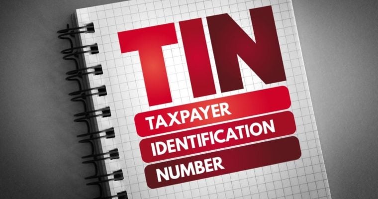 Open Notebook on Grey Background Reads TIN Taxpayer Identification Number