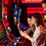 Three People Having Fun Inside Colorful Casino Slots Lounge