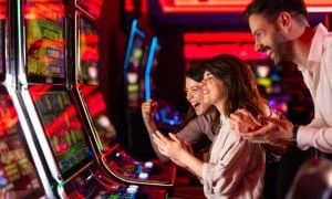 Three People Having Fun Inside Colorful Casino Slots Lounge