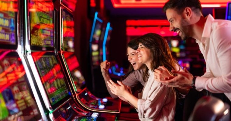 Three People Having Fun Inside Colorful Casino Slots Lounge