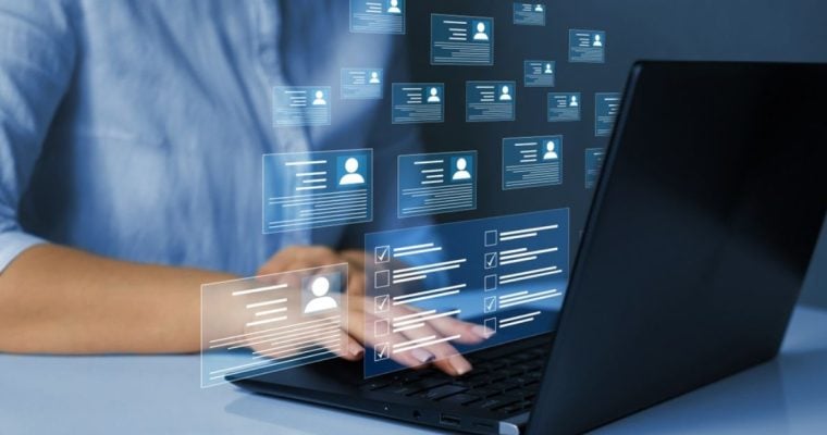 Digital Icons of Personal Profiles Displayed In Front of Laptop While Woman Reviews Them