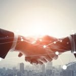 Two Businessmen Shake Hands Above City Skyline with Geolocation Dots Overlay