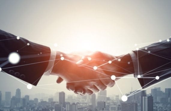 Two Businessmen Shake Hands Above City Skyline with Geolocation Dots Overlay